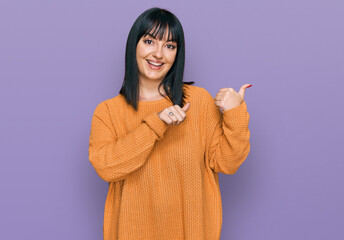 Canvas Print - Young hispanic woman wearing casual clothes pointing to the back behind with hand and thumbs up, smiling confident