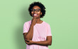 © Krakenimages.com - African american woman with afro hair wearing casual clothes and glasses looking confident at the camera smiling with crossed arms and hand raised on chin. thinking positive.