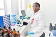 © Krakenimages.com - African woman working at scientist laboratory scared and amazed with open mouth for surprise, disbelief face