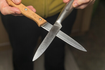 Two metal crossed knives in his hands