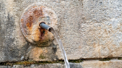 spring water flowing from an ancient natural stone spring