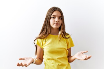 Sticker - Young brunette teenager standing together over isolated background clueless and confused with open arms, no idea concept.