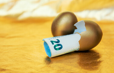 Wall Mural - golden eggs with 20 euro banknotes on gold table, concept of enrichment and wealth	
