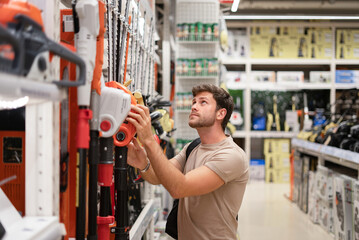 Guy shopping in store of power tools