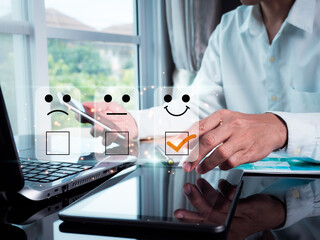 A man points with his finger and selects a face smiling emoticon to display on the virtual screen. A survey, poll, designed to gather information about user experience or customer satisfaction.