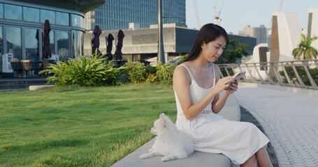 Wall Mural - Woman go out with her dog and use of smart phone