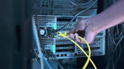 engineer it technician sets up system. african-american man switches colorful cables spbas to run ch