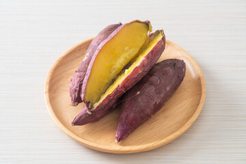 Wall Mural - Grilled or baked Japanese sweet potatoes on wood plate