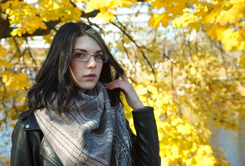 Wall Mural - portrait of  young girl in city park on an autumn day