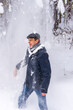 © Tatyana_Andreyeva - Portrait of middle-aged man having fun while shaking snow from tree branches in winter forest after snowfall. Winter holidays, active leisure, weekend trip to countryside concept