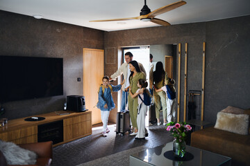 happy young family with two children enetring room at luxury hotel, summer holiday.