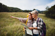 © Halfpoint - Happy mid adult woman with active senior mother hiking and looking at map outdoors in nature.
