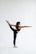 © F8  \ Suport Ukraine - Young modern flexible girl standing on one leg split on isolated white background.
