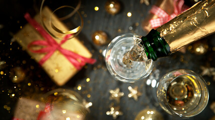 Wall Mural - Champagne pouring in a glass from a bottle, top view.