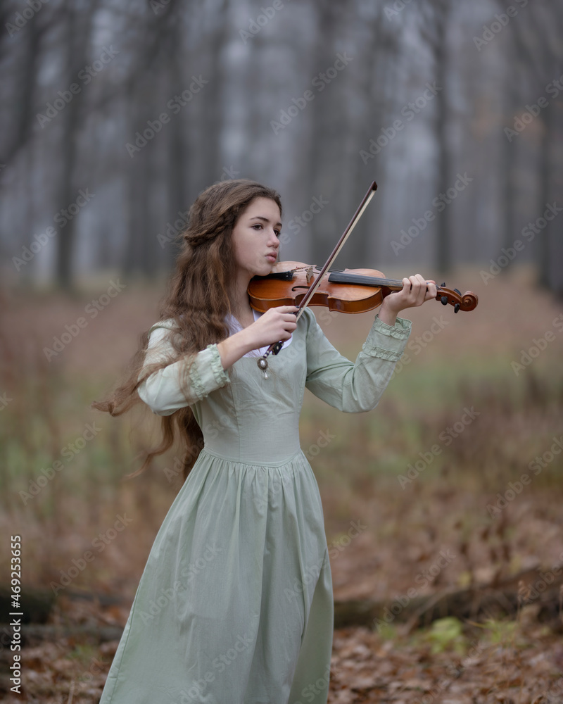 Young girl playing violin in autumn misty forest Stock Photo | Adobe Stock