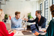 © Westend61 - Businessmen giving fist bump to colleague in meeting