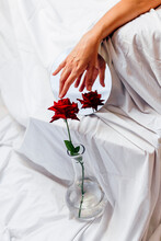 Woman Touching Red Rose In Vase With Reflection On Mirror