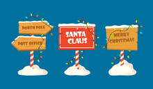 Set Cute Collection North Pole Signboards And Christmas Wooden Street Signs In Snow, Winter Pointers With Garlands, Snow