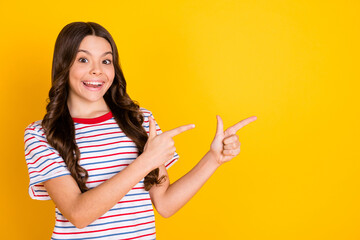 Wall Mural - Photo of young cheerful girl happy smile indicate fingers empty space ad promo recommend advise isolated over yellow color background