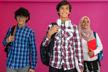 Wall Mural - A group of Arab teenagers, a student team walking forward into the future and back to school the concept of a pink background. The concept of successful education for young people. Selective focus