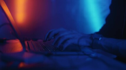 Hacker is working on laptop at night. Hands are typing a virus code at keyboard or hacking website. Concept of bitcoin cryptocurrency and wallet hack. Software coder or blockchain developer