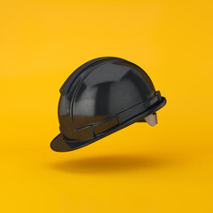 Wall Mural - Hard hat black floating on a yellow background, 3d render