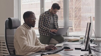 Wall Mural - stab shot of two young multiethnic male programmers working together on new project in contemporary 