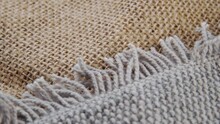 Gray Jute Rug With Fringe On A Rough Rustic Burlap Fabric. Textured Vintage Surface. Macro. Slow Rotation