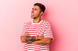 © Asier - Young caucasian man with tattoos isolated on yellow background  funny and friendly sticking out tongue.