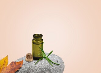 Wall Mural - cosmetic oil in a jar with a dropper on a stone with leaf. Autumn theme.