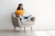 © Prostock-studio - Remote Work. Smiling Female Using Laptop While Sitting In Armchair At Home