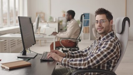 Wall Mural - stab side-view medium slowmo portrait of young software developer in casualwear and eyeglasses worki