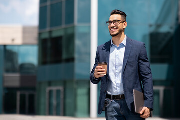 Wall Mural - Cheerful middle eastern businessman with laptop and cup of coffee