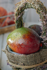 Canvas Print - Fresh and ripe mango in a basket on white table