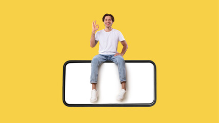 Man sitting on white empty smartphone screen showing okay sign