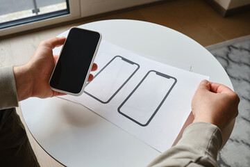 Designer is developing a UX mobile application wireframe. Sketch, prototype, framework, layout future app design for smartphone. UI/UX - user interface and user experience designer. App development