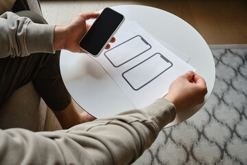 Designer is developing a UX mobile application wireframe. Sketch, prototype, framework, layout future app design for smartphone. UI/UX - user interface and user experience designer. App development