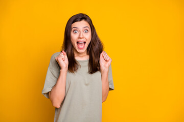 Sticker - Photo of young happy excited smiling cheerful shocked amazed girl win lottery isolated on yellow color background