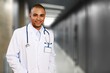 © BillionPhotos.com - Smiling doctor wearing medical coat looking at camera.
