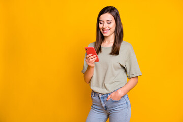 Poster - Portrait of attractive cheerful focused girl using gadget app browsing multimedia isolated over bright yellow color background