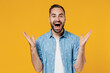 Young happy joyful fun surprised overjoyed excited caucasian man 20s wear blue shirt white t-shirt spread hands scream isolated on plain yellow background studio portrait. People lifestyle concept