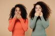 Two secret amazed young curly black women friends 20s wearing casual shirts clothes cover mouth with hand isolated on plain pastel beige background studio portrait. People emotions lifestyle concept.