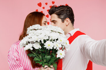 Wall Mural - Close up young two friends woman man in casual shirt doing selfie shot pov on mobile phone hold flowers kiss isolated on plain pastel pink background. Valentine's Day birthday holiday party concept.