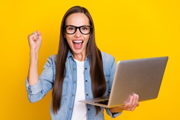 Sticker - Photo of young crazy lady celebrate victory lucky fists hand use laptop sale isolated over yellow color background.