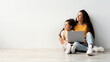 Happy Young Mother And Little Daughter Sitting With Laptop On Floor