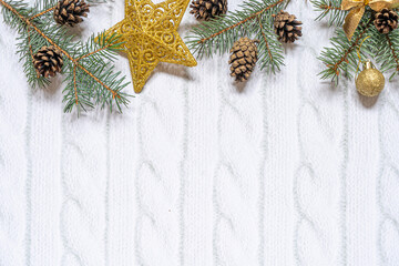 Christmas composition. Christmas gift, knitted blanket, pine cones, fir branches on wooden white background. Flat lay, top view, copy space