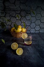 Still Life With Lemons On The Table On A Dark Background And A Glass Of Water With Lemon