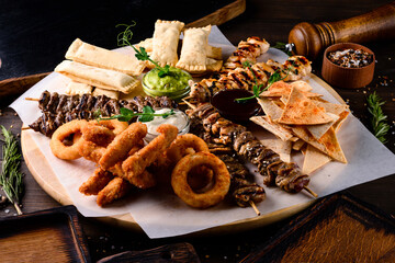 Poster - set of shish kebab and snacks onion rings and snacks on wooden plate