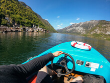 Man Controls A Motorboat On A Mountain Lake