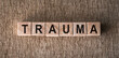 the word trauma written on wooden cubes